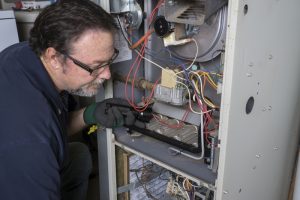 technician-looks-at-gas-furnace