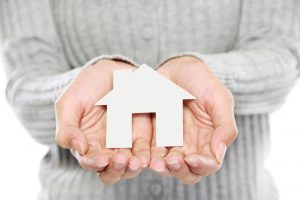 hands-of-a-woman-holding-a-white-paper-house