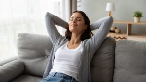 woman-comfortable-on-her-couch-leaning-back-with-closed-eyes
