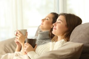 two-women-sitting-back-on-couch-looking-comfortable