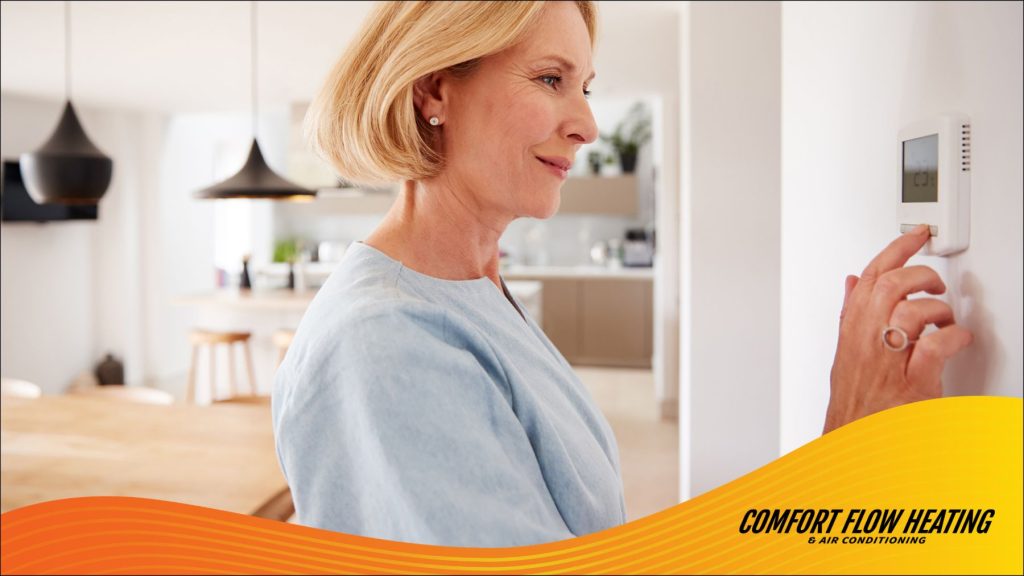 A homeowner adjusting her thermostat.